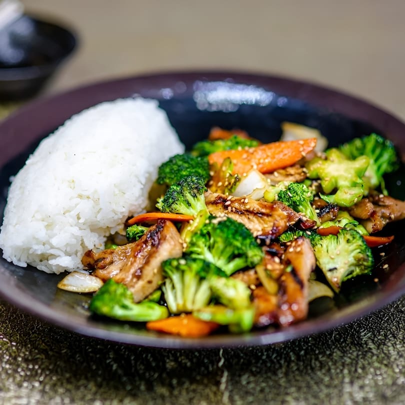 Jackpot Teriyaki chicken teriyaki with broccoli, carrots, onions, sesame seeds, and white rice.