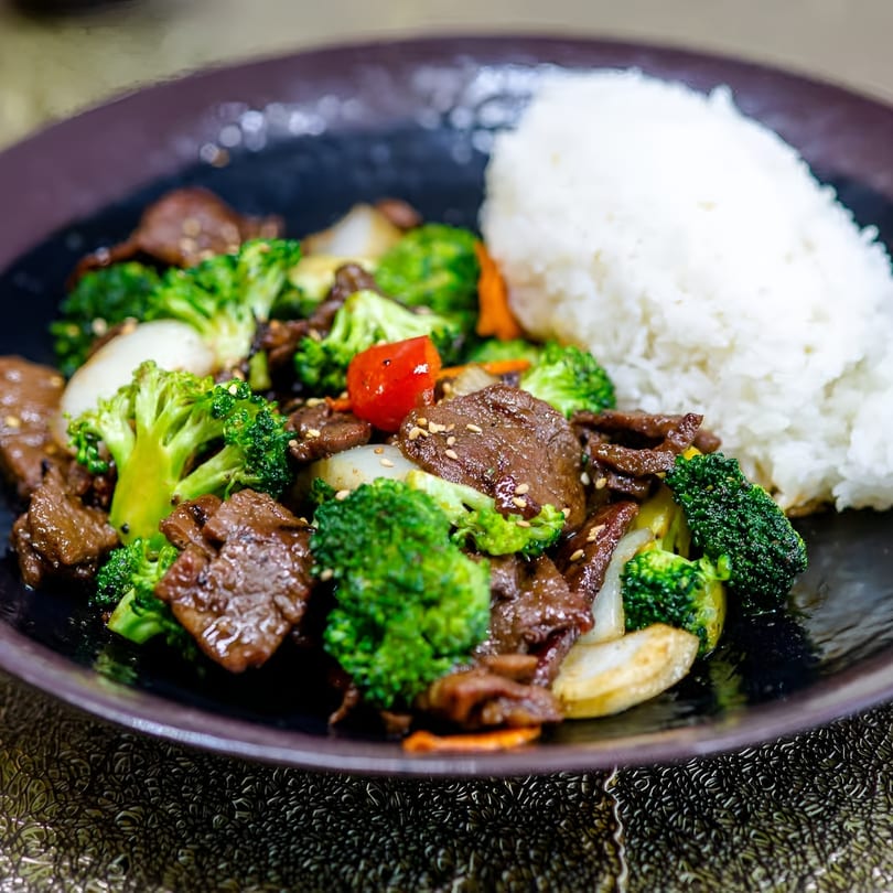 Jackpot Teriyaki's beef and broccoli stir-fry with white rice, garnished with sesame seeds.