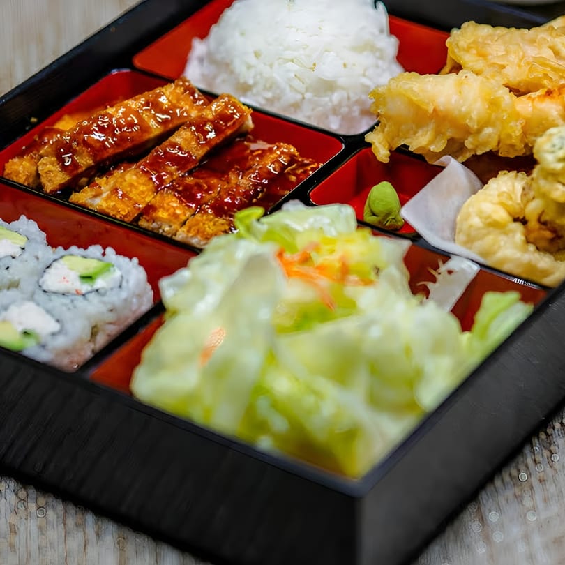 A Jackpot Teriyaki bento box with teriyaki chicken, rice, tempura, sushi, and salad.